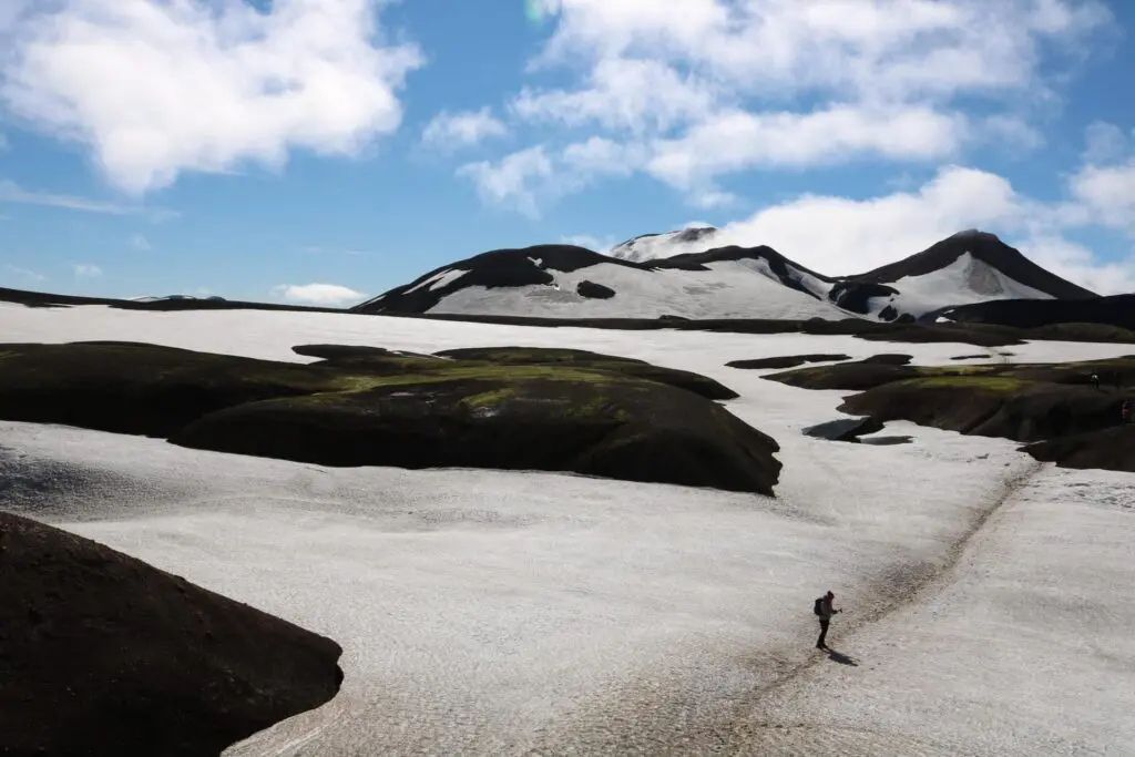 hiker on snowy trail in icelandic mountains