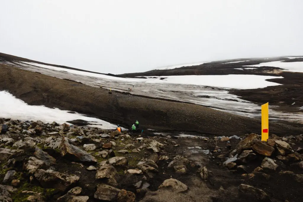 hikers on a snowy and rocky trail in Iceland